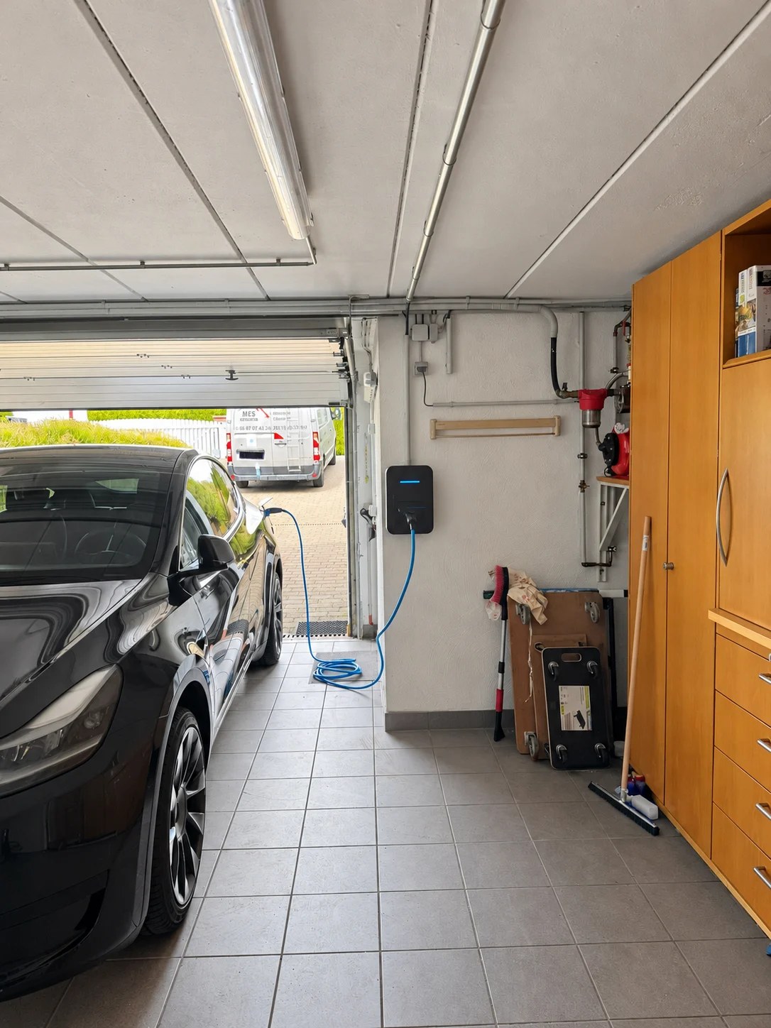 Voiture en recharge dans un garage, borne installée par MES Électricité